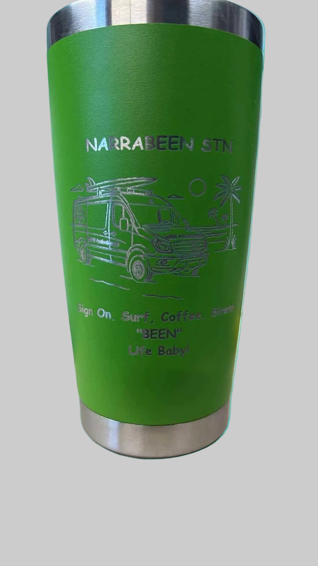 Green insulated mug with branding on a surface